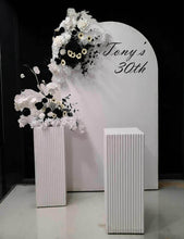 Load image into Gallery viewer, White arch backdrop, 2 x black & white flowers, 2 x white square ripple plinths - HIRE ONLY