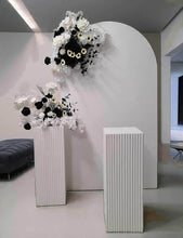 Load image into Gallery viewer, White arch backdrop, 2 x black & white flowers, 2 x white square ripple plinths - HIRE ONLY