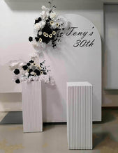 Load image into Gallery viewer, White arch backdrop, 2 x black & white flowers, 2 x white square ripple plinths - HIRE ONLY