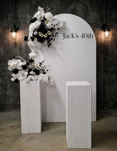 Load image into Gallery viewer, White arch backdrop, 2 x black & white flowers, 2 x white square ripple plinths - HIRE ONLY