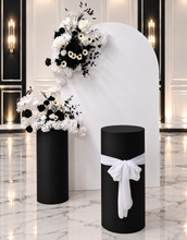 Load image into Gallery viewer, White arch backdrop, 2 x black & white flowers, 2 x black cylinder plinths - HIRE ONLY