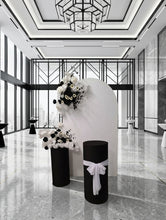 Load image into Gallery viewer, White arch backdrop, 2 x black & white flowers, 2 x black cylinder plinths - HIRE ONLY