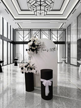 Load image into Gallery viewer, White arch backdrop, 2 x black & white flowers, 2 x black cylinder plinths - HIRE ONLY