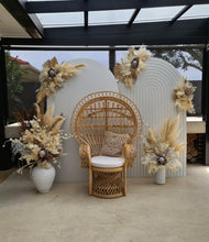 Load image into Gallery viewer, Two white backdrops / arches &amp; 5 x boho flowers &amp; Queen Peacock chair - HIRE ONLY
