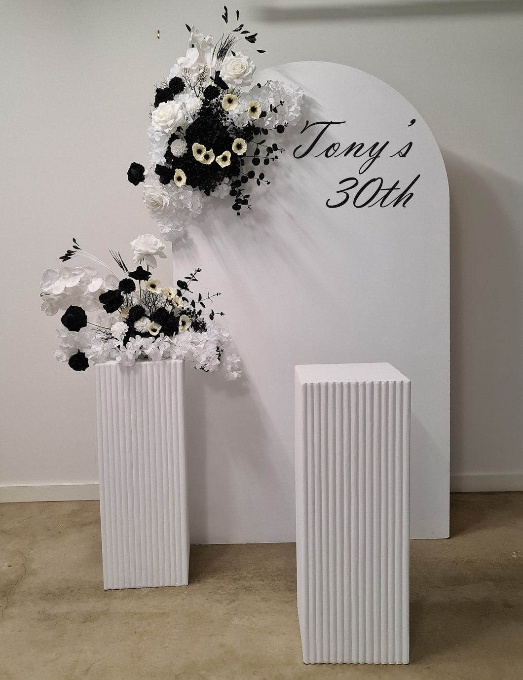 White arch backdrop, 2 x black & white flowers, 2 x white square ripple plinths - HIRE ONLY