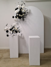 Load image into Gallery viewer, White arch backdrop, 2 x black &amp; white flowers, 2 x white square ripple plinths - HIRE ONLY
