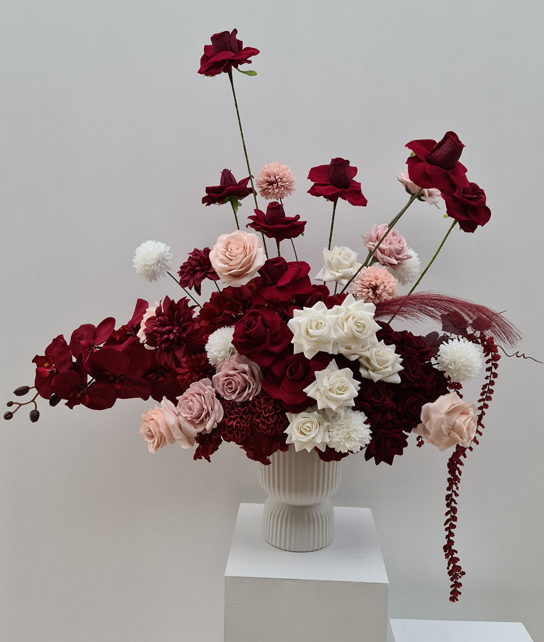 Burgundy, pink & white floor / plinth flowers in white ribbed pot - HIRE ONLY